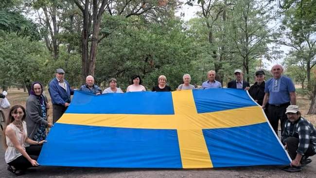 Residents of Kherson region with the flag of Sweden. PHOTO: Svitlana Zalishchuk's Facebook page